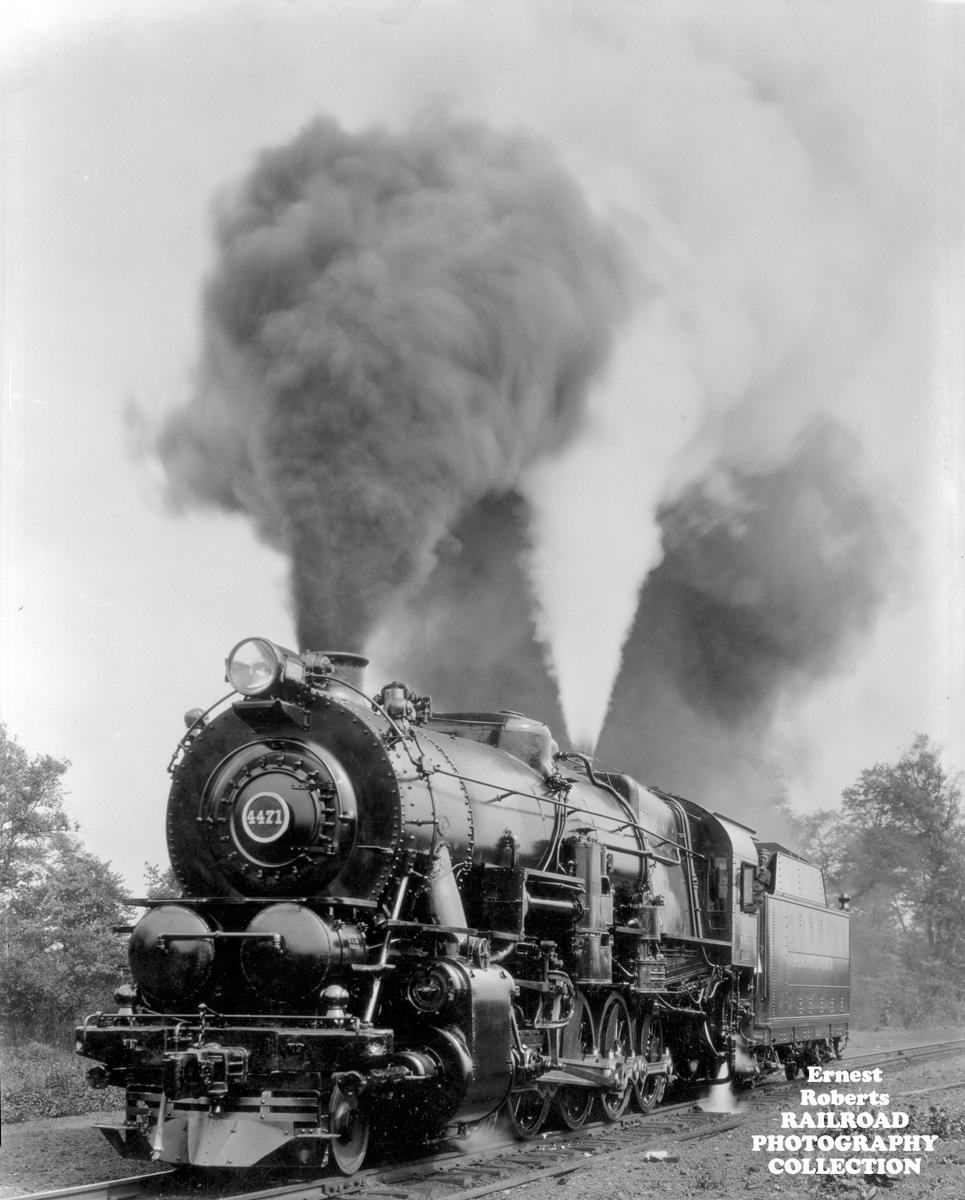 Black and white photograph of Pennsylvania Railroad steam engine No. 4471 standing on the track under two towering columns of smoke and steam